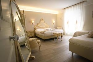 a bedroom with two beds and a mirror at Hotel Villa Margherita in Quercianella