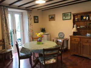 a kitchen with a table with a vase of flowers on it at Meadow Sweet Cottage in Okehampton