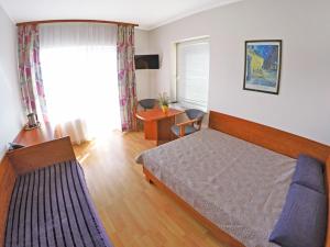 a bedroom with a bed and a desk and a window at Baltic Neptun in Jastrzębia Góra