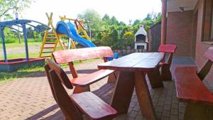 a wooden picnic table and chairs with a playground at Baltic Neptun in Jastrzębia Góra