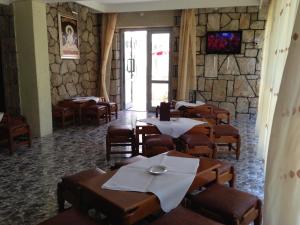 a restaurant with tables and chairs and a stone wall at Hotel Ovidiu in Mamaia