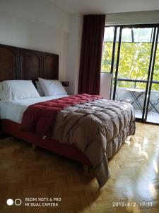 1 dormitorio con 1 cama grande y ventana grande en Bosques & Lagos Palermo en Buenos Aires
