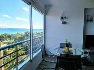 een balkon met een tafel en stoelen en uitzicht op de oceaan bij BSB Surf&Beach Apartment Salou in Salou