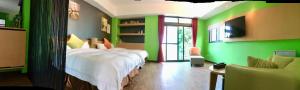 a green room with a bed and a tv at Great Nature Villa in Jiji