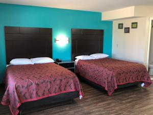 two beds in a hotel room with blue walls at Euro Inn & Suites of Slidell in Slidell
