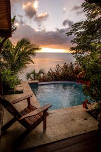 a swimming pool with a bench and a view of the ocean at Calabash Cove Resort and Spa - Adults Only in Gros Islet