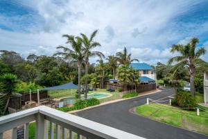 - un balcon donnant sur un complexe avec piscine et palmiers dans l'établissement Boathouse Resort Studios and Suites, à Blairgowrie