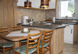 een keuken met een houten tafel en een aantal stoelen bij Ferienwohnung Bücker in Schmallenberg +19 foto's