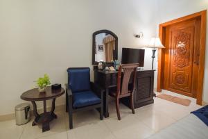 a room with a desk and a chair and a table at Homesyn Hotel in Phnom Penh