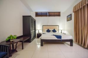 a bedroom with a king sized bed and a table at Homesyn Hotel in Phnom Penh