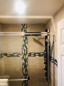 La salle de bains est pourvue d'une douche avec une porte en verre. dans l'établissement Sunset Beach Hotel, à Wildwood