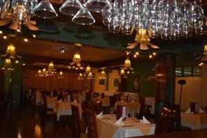 une salle à manger avec des tables blanches et des lustres dans l'établissement Royal Inn Hotel Puno, à Puno