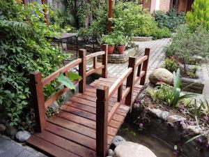 a wooden bridge over a pond in a garden at Hotel Middle Path & Spa in Pokhara