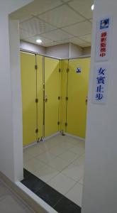 a bathroom with yellow stalls in a building at Guotai Backpack in Kaohsiung