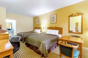 a hotel room with two beds and a desk at Quality Inn & Suites in Dickson