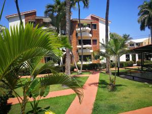 a courtyard with palm trees and a building at Apartment Costambar Puerto Plata in San Felipe de Puerto Plata