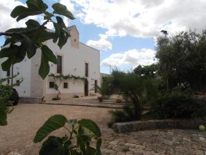 an external view of a white building with trees at Masseria Nonna Angela in Putignano