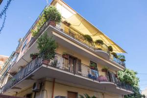 a building with balconies and potted plants on it at Casa Grazia Letojanni Centro in Letojanni