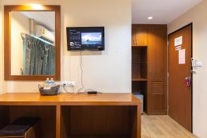 a room with a desk with a television on the wall at Sleep at Phuket SHA Plus in Phuket Town