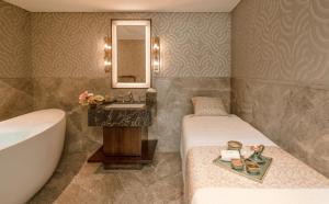 a bathroom with a tub and a bed and a sink at Taj Coromandel in Chennai