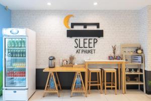 a coffee shop with two tables and a refrigerator at Sleep at Phuket SHA Plus in Phuket Town