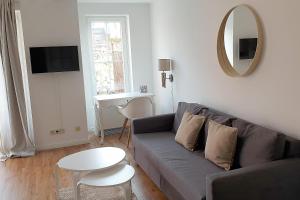 ein Wohnzimmer mit einem Sofa, einem Tisch und einem Spiegel in der Unterkunft Ferienwohnung *Windstille* in Wittdün