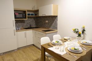 cocina con mesa de madera y armarios blancos en Apartmány MAX, en Vaclavov u Bruntalu