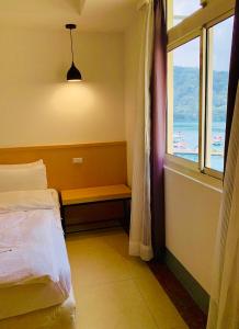 a bedroom with a bed and a window with the ocean at Tai Hu Hotel Sun Moon Lake in Yuchi