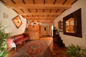 salon z czerwoną kanapą i lustrem w obiekcie Hotel Dalla Serra w mieście Mezzana +37 zdjęć