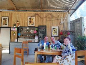 een groep mensen aan een tafel in een restaurant bij Meexai Guesthouse in Nongkhiaw