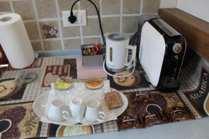 a counter top with a coffee maker and cups on a table at Rina Rooms in Vernazza