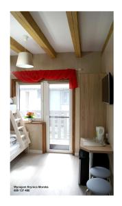 a room with a window and a bed and a table at Los Reyes II - klimatyzowane pokoje in Krynica Morska +35 photos