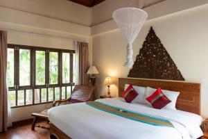 a bedroom with a large bed with a christmas tree on the wall at Royal Lanta Resort & Spa in Ko Lanta