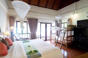a bedroom with a bed and a living room at Royal Lanta Resort & Spa in Ko Lanta
