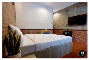 a bedroom with a bed with a teddy bear on it at เซฟเฮ้าส์รีสอร์ท บางใบไม้ in Suratthani
