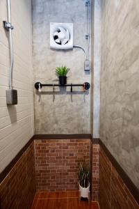 a bathroom with a shower with a brick wall at เซฟเฮ้าส์รีสอร์ท บางใบไม้ in Suratthani
