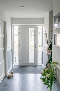 a hallway with a door leading to a patio at BnB 't Kraaiennest in De Cocksdorp