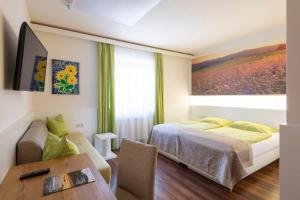 a bedroom with a bed and a table and a window at Gasthof Pack "Zur Lebing Au" in Hartberg