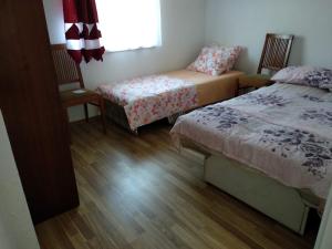 a bedroom with two beds and a chair and a window at Family House Near Motorway 6 Guests 3 Bedrooms in Veles