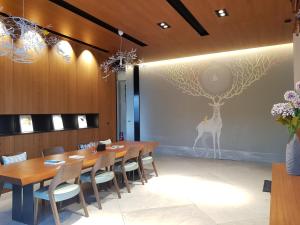 a dining room with a table and a deer on the wall at Grange Inn in Taitung City