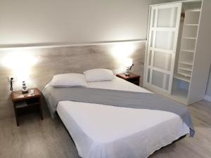 um quarto com duas camas e duas mesas de cabeceira em Estudios los Arcos em Teruel