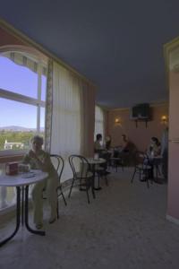 uma mulher sentada numa mesa num quarto de hotel em Hostal Europa em Estepona
