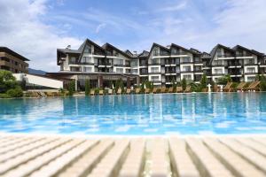 a large swimming pool in front of a building at Aspen golf studio apartment D208 in Razlog