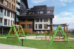 a playground with two swings in front of a building at Aspen golf studio apartment D208 in Razlog