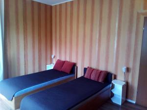 duas camas num quarto com paredes listradas em Owocowy Domek em Samotwór