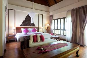 a bedroom with a large bed with pink pillows at Royal Lanta Resort & Spa in Ko Lanta