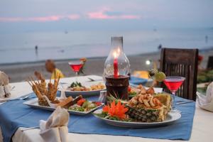 a table with plates of food on the beach at Royal Lanta Resort & Spa in Ko Lanta