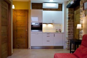 a kitchen with white cabinets and a stove top oven at Apartamentos Playa Galizano in Galizano