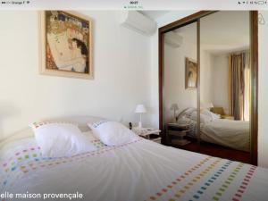 um quarto com uma cama branca e um espelho em Lou Parpaillou em Éguilles