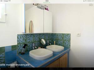 a bathroom with two sinks on a blue counter at Lou Parpaillou in Éguilles